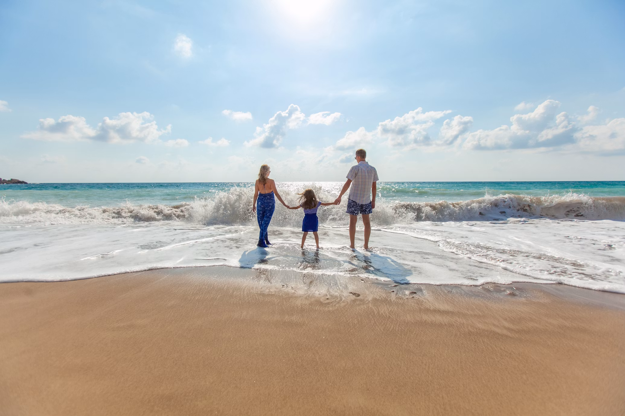 A family holding hands together on the beach